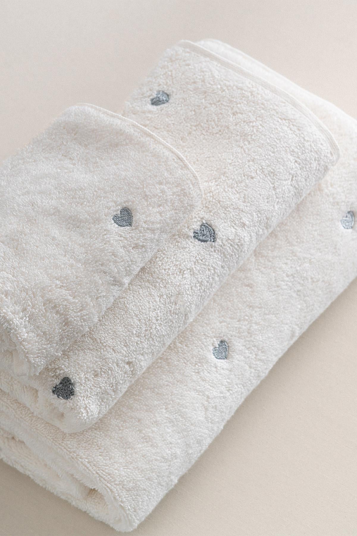 Ensemble de serviettes blanc, détail cœur argenté, texture douce, accessoire de bain confortable
