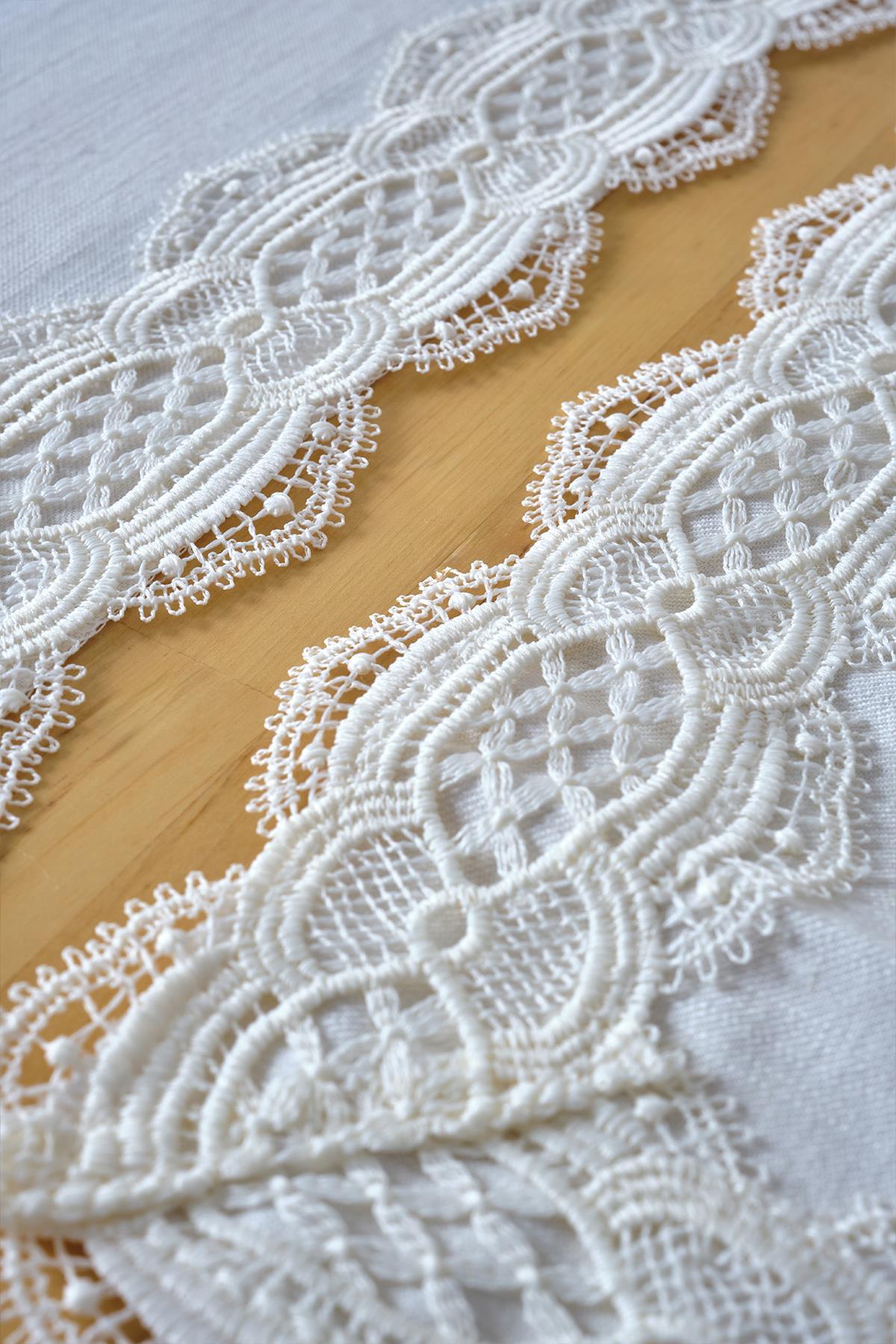 Set de table blanc avec détails en dentelle posé sur une nappe