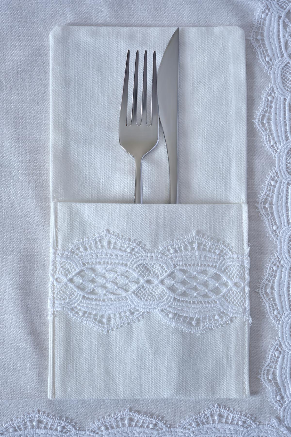 Couverts avec fourchette et couteau sur une serviette blanche à détails en dentelle, élégant dressage de table