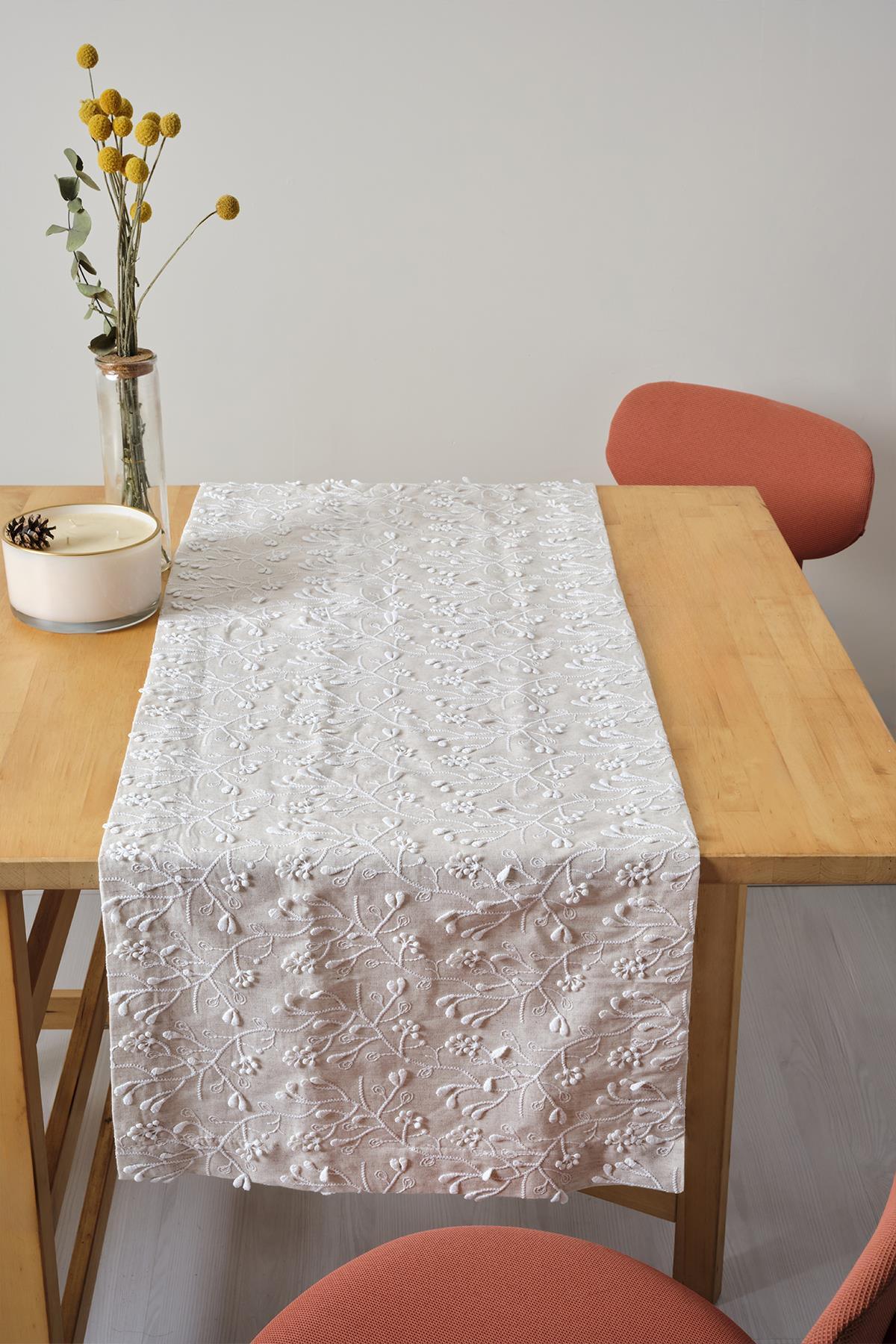 Nappe avec broderie en dentelle, présentation décorative sur une table en bois naturel