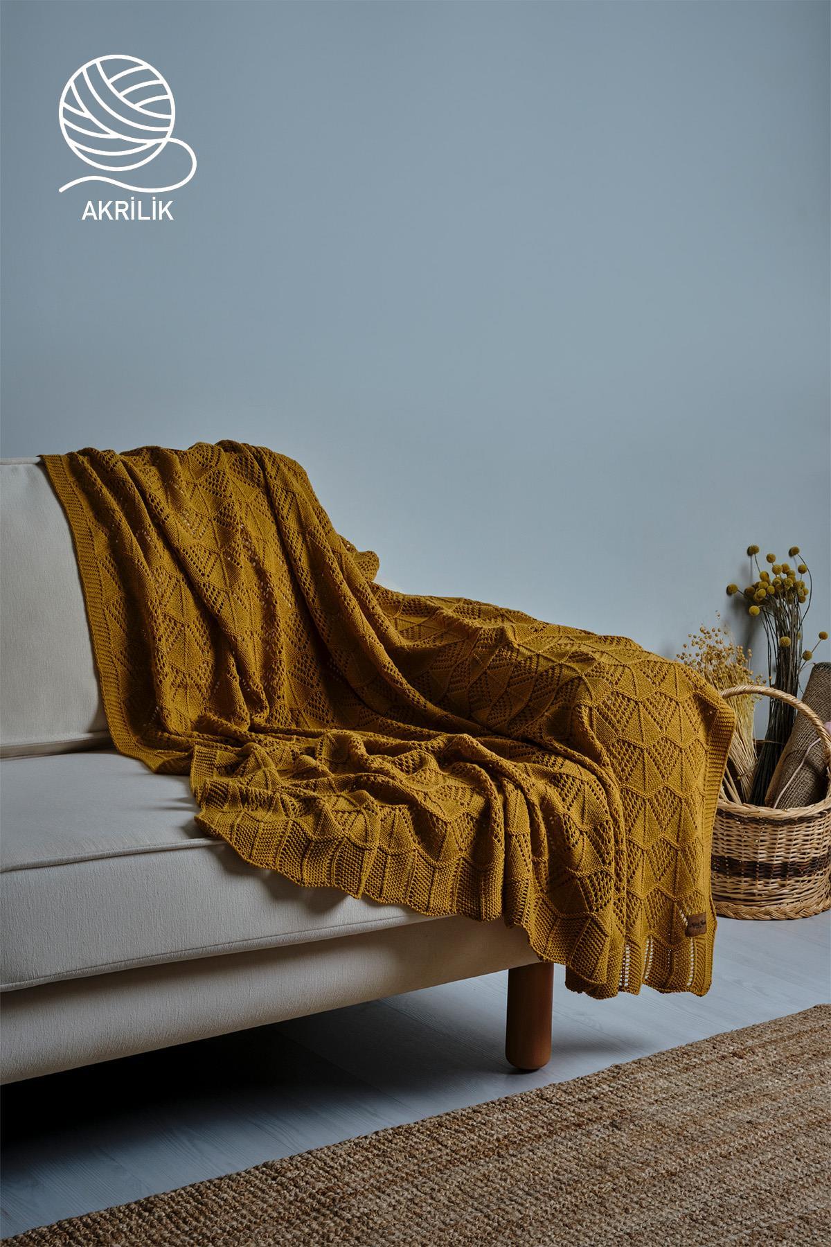 Couverture TV en tricot épais jaune en acrylique, disposée de manière décorative sur un canapé