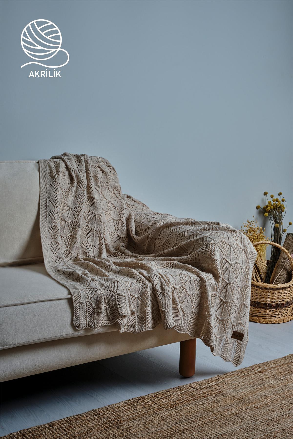 Couverture TV en tricot acrylique couleur crème, disposée sur un canapé dans une pièce à la décoration moderne