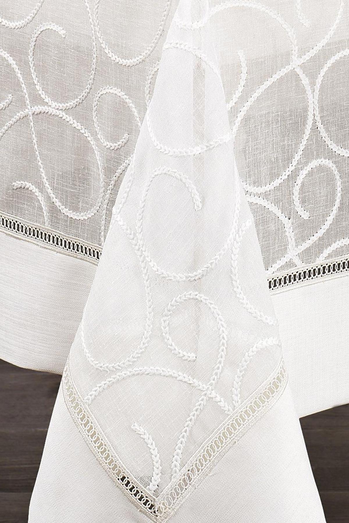 Nappe blanche à motifs, antitache, tissu facile d'entretien, avec détails décoratifs sur les bords.