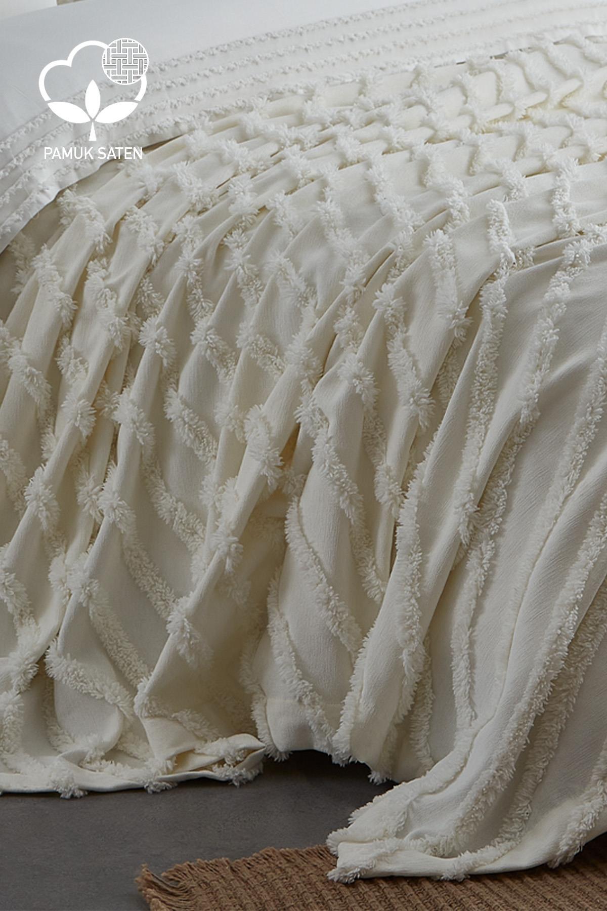 Parure de lit double en satin de coton crème avec couvre-lit texturé, disposée sur un lit
