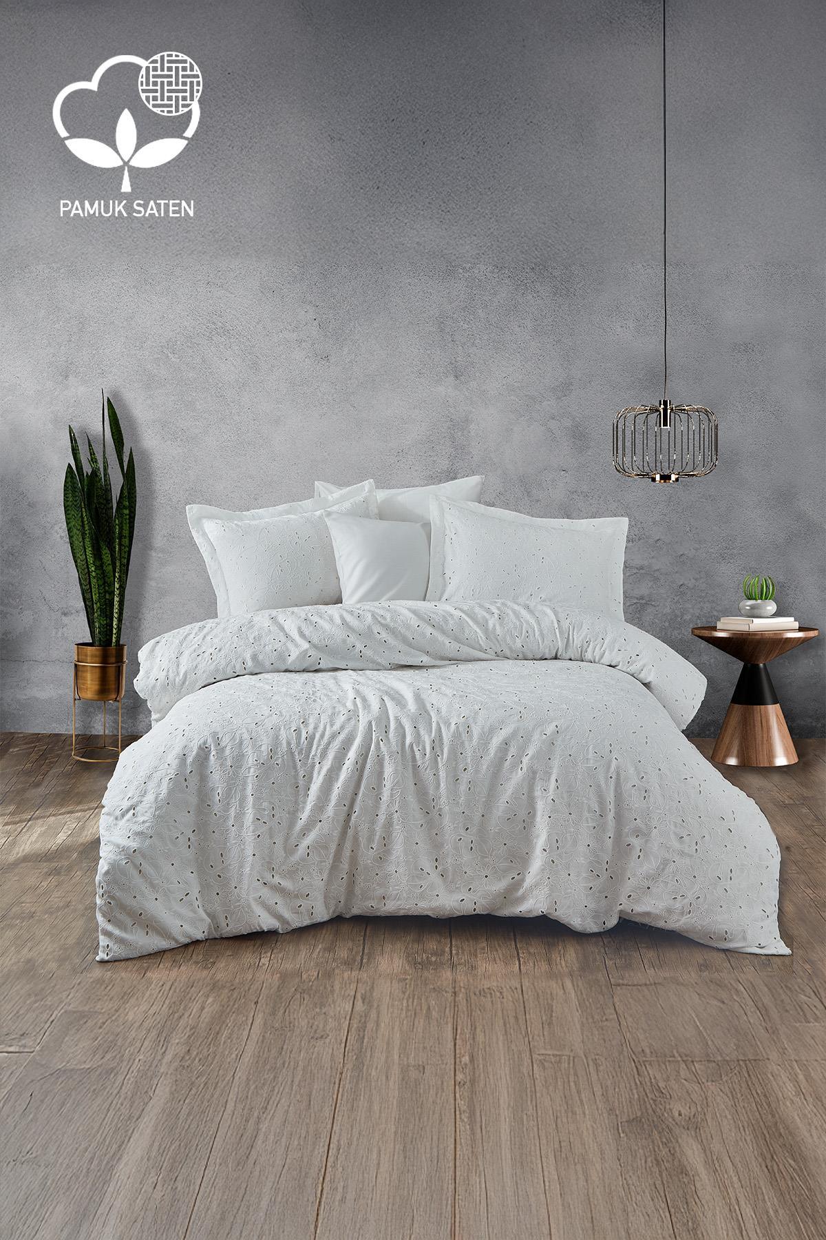 Parure de lit double en satin de coton blanc avec broderies Nill, dans une chambre moderne
