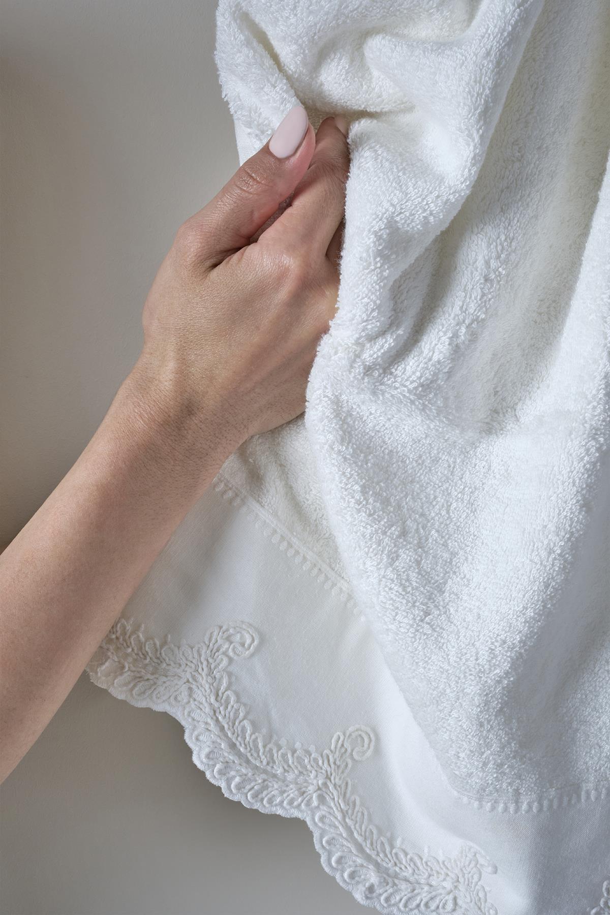 Serviette à main blanche brodée à la main avec bordure en dentelle, tenue à la main