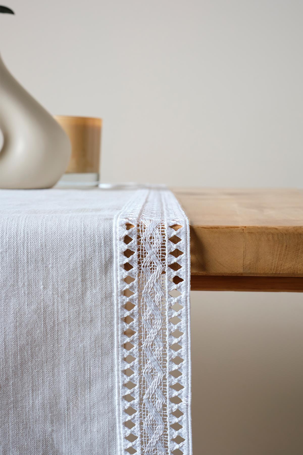 Chemin de table blanc en dentelle, élégant linge de table décoratif sur une table en bois