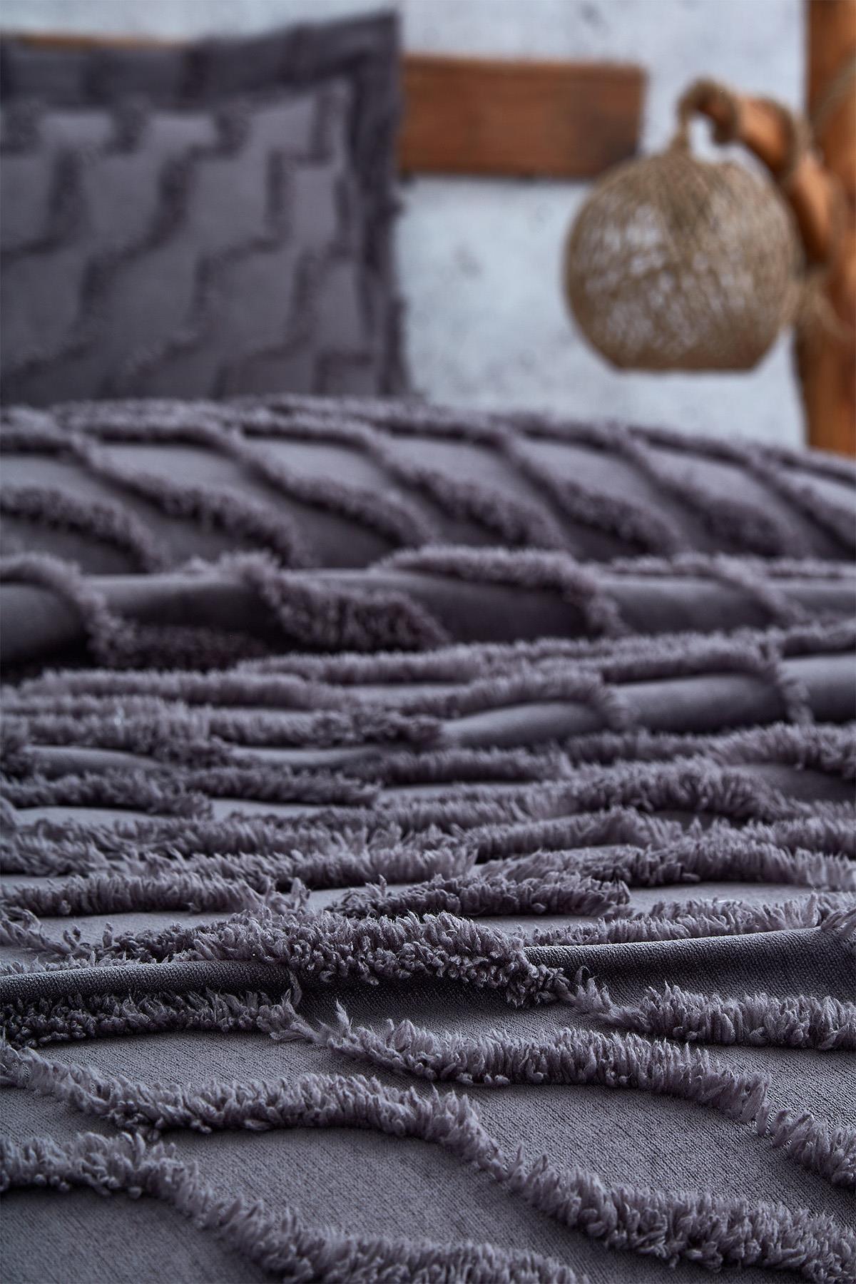 Gros plan sur un couvre-lit une personne violet à texture lin avec taie d'oreiller assortie