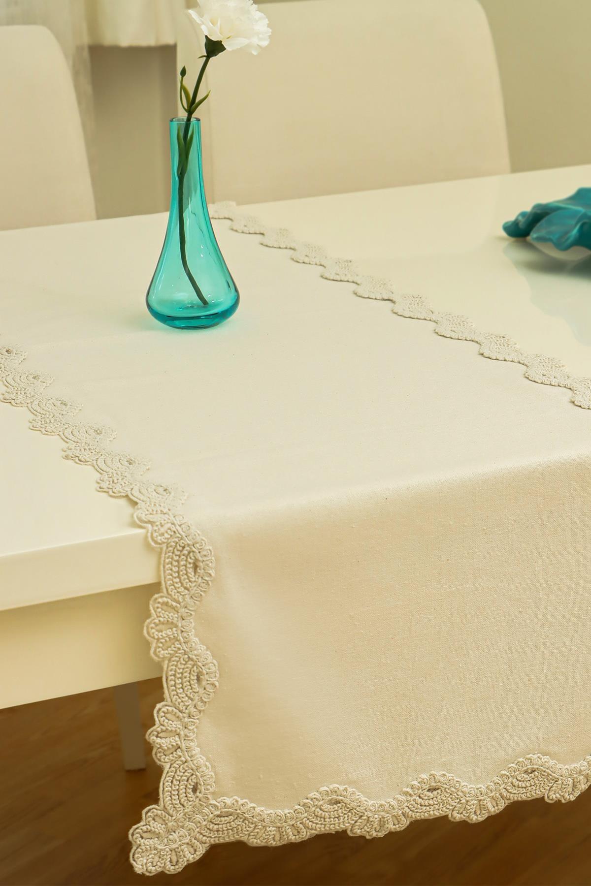 Chemin de table crème à détails en dentelle, avec un vase décoratif sur une table à manger moderne