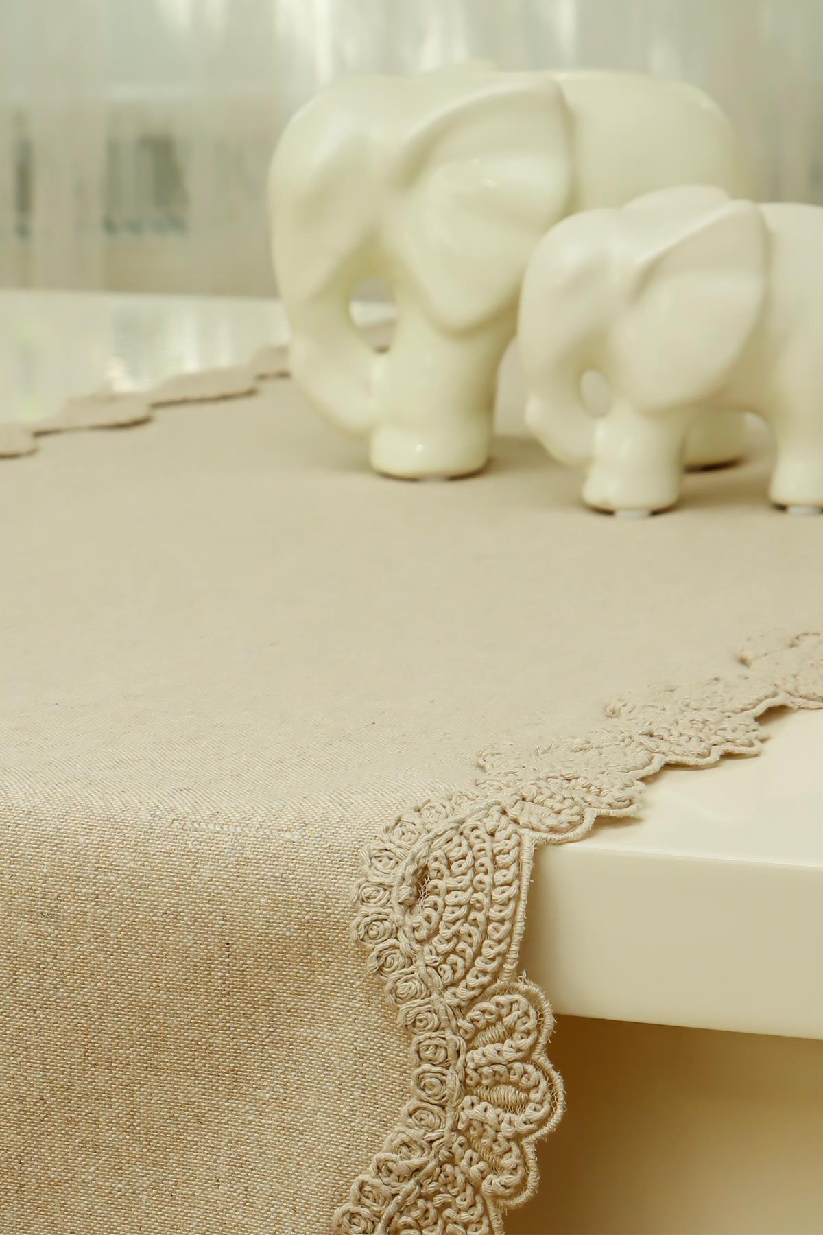 Nappe crème à bordure en dentelle avec des décorations d'éléphants en porcelaine