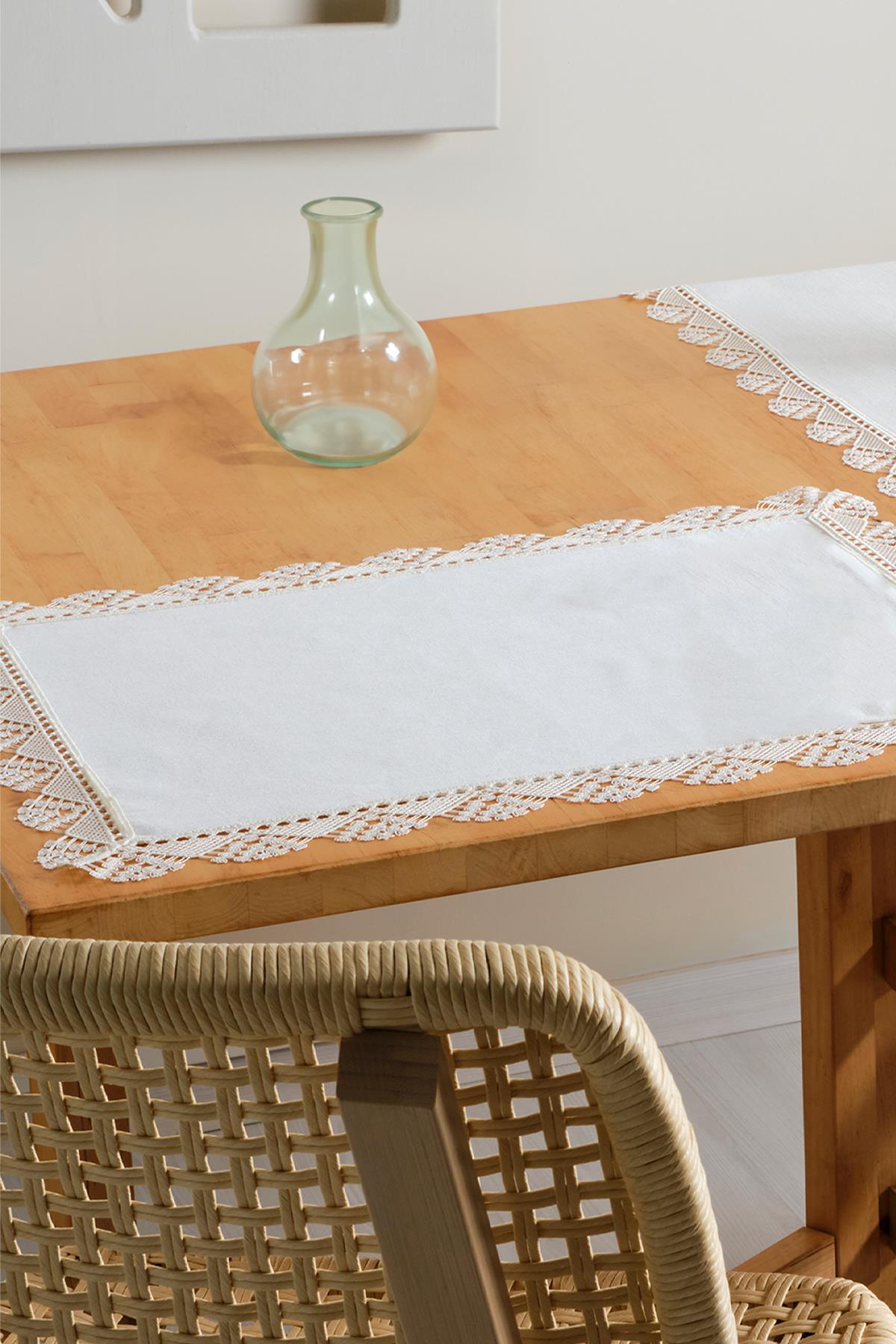 Set de table blanc à bordure en dentelle sur une table en bois, décoration de table avec un vase en verre