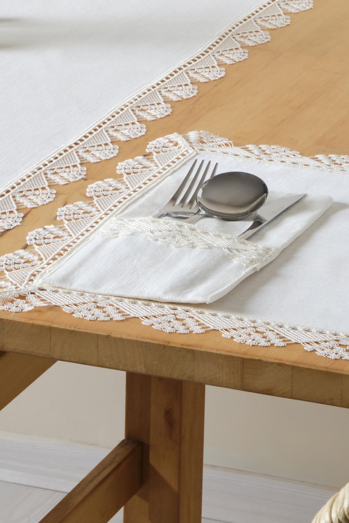 Nappe en dentelle et ensemble de serviettes blanches avec couverts, sur une table en bois