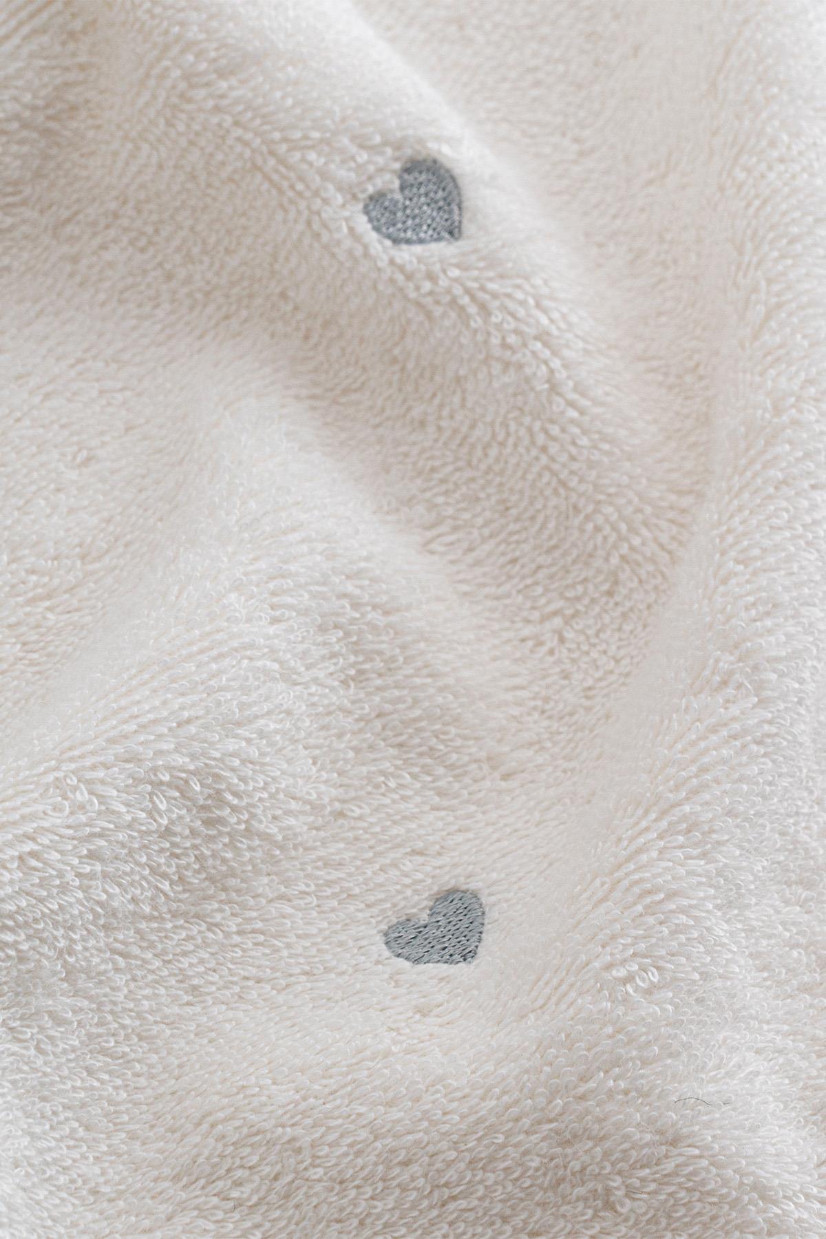 Serviette douce blanche à motif de cœurs gris, pour un intérieur confortable et élégant