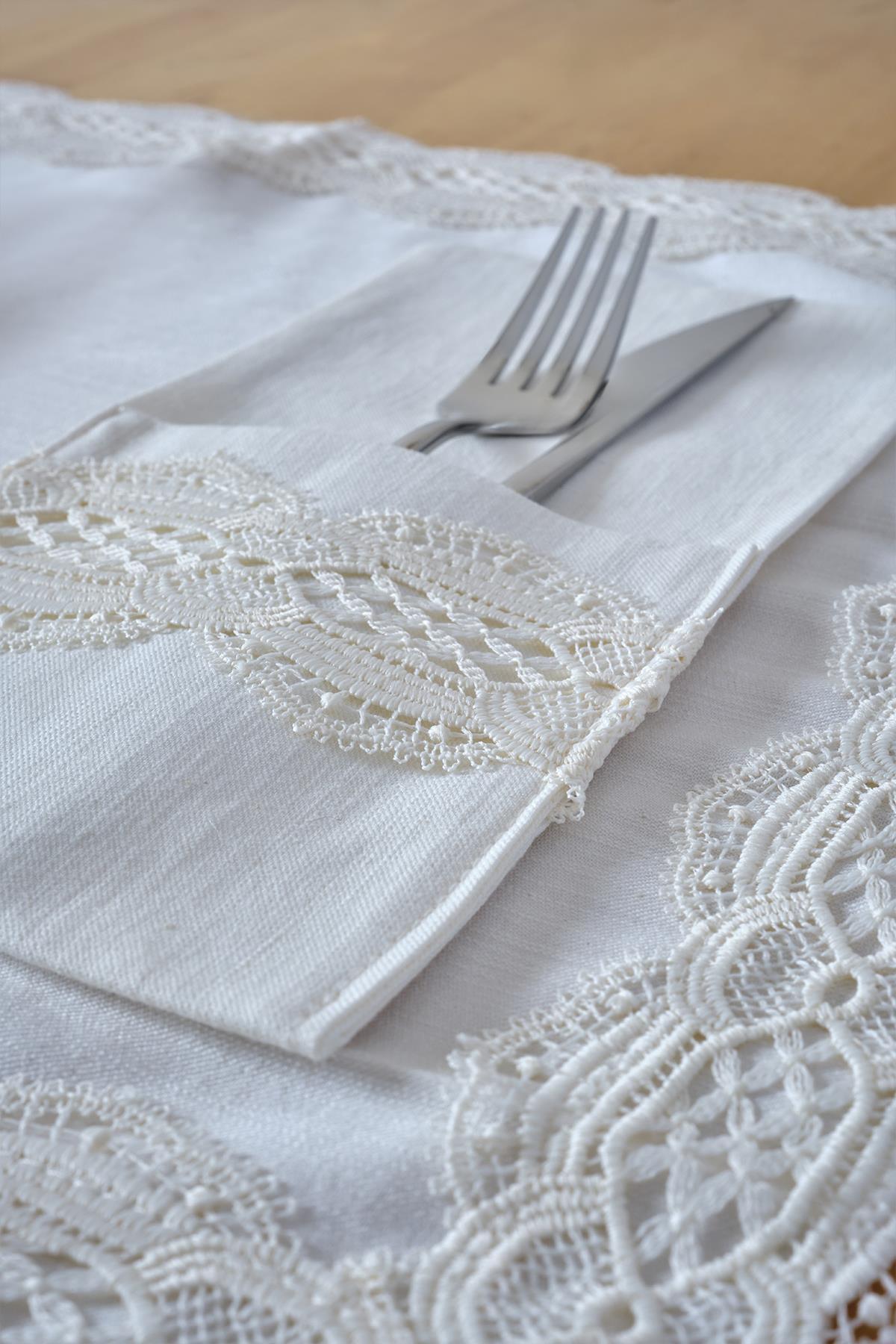 Couverts posés sur une serviette en tissu blanc avec détails en dentelle