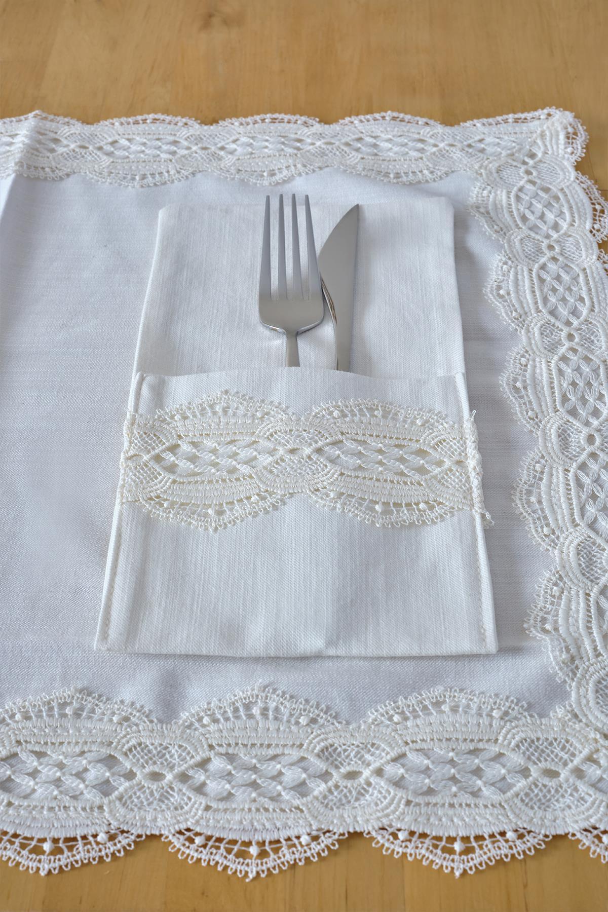 Ensemble de porte-serviettes élégant avec fourchette et couteau sur une nappe blanche à bordure en dentelle