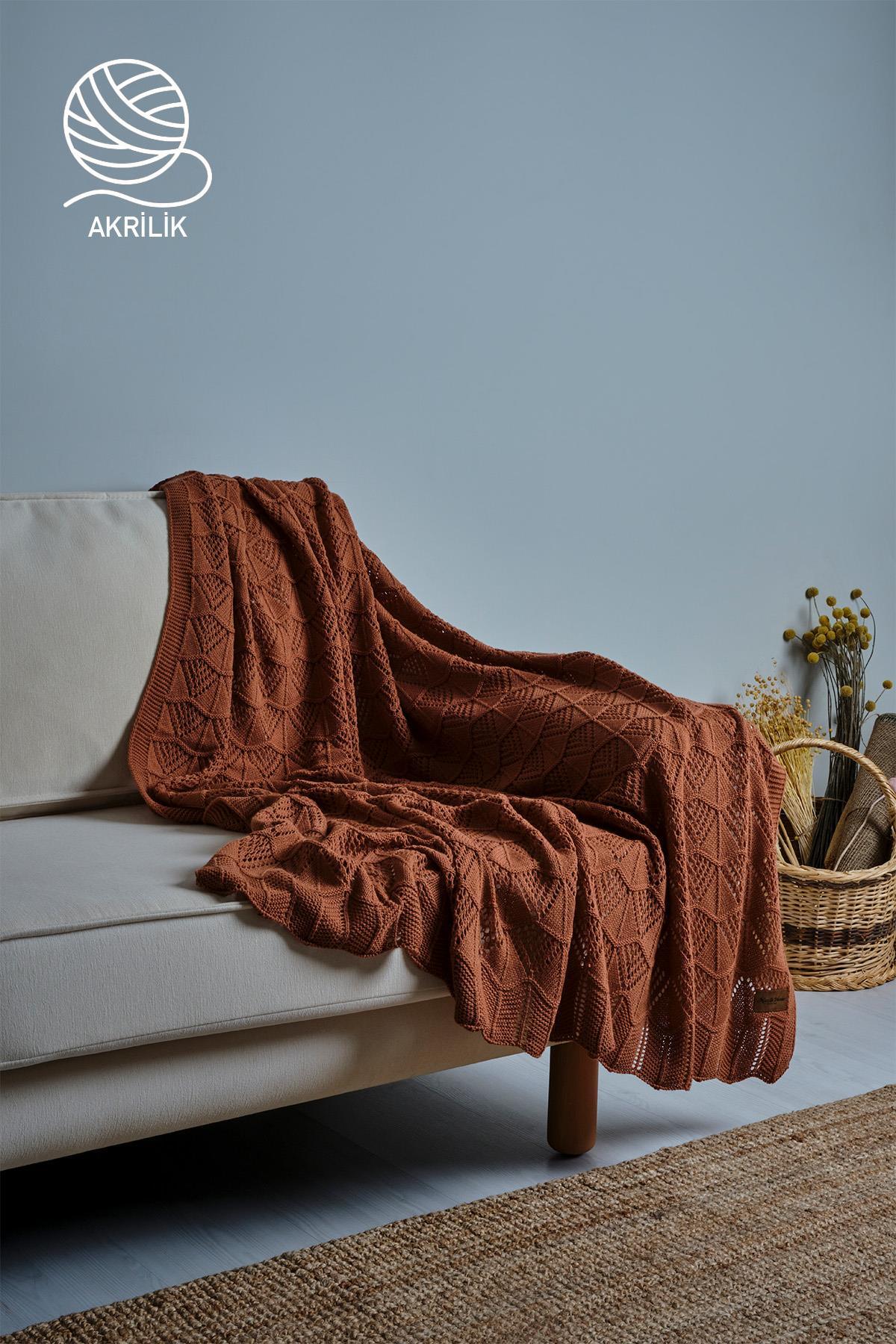 Couverture TV en tricot épais marron en acrylique, posée sur un canapé crème et un panier décoratif