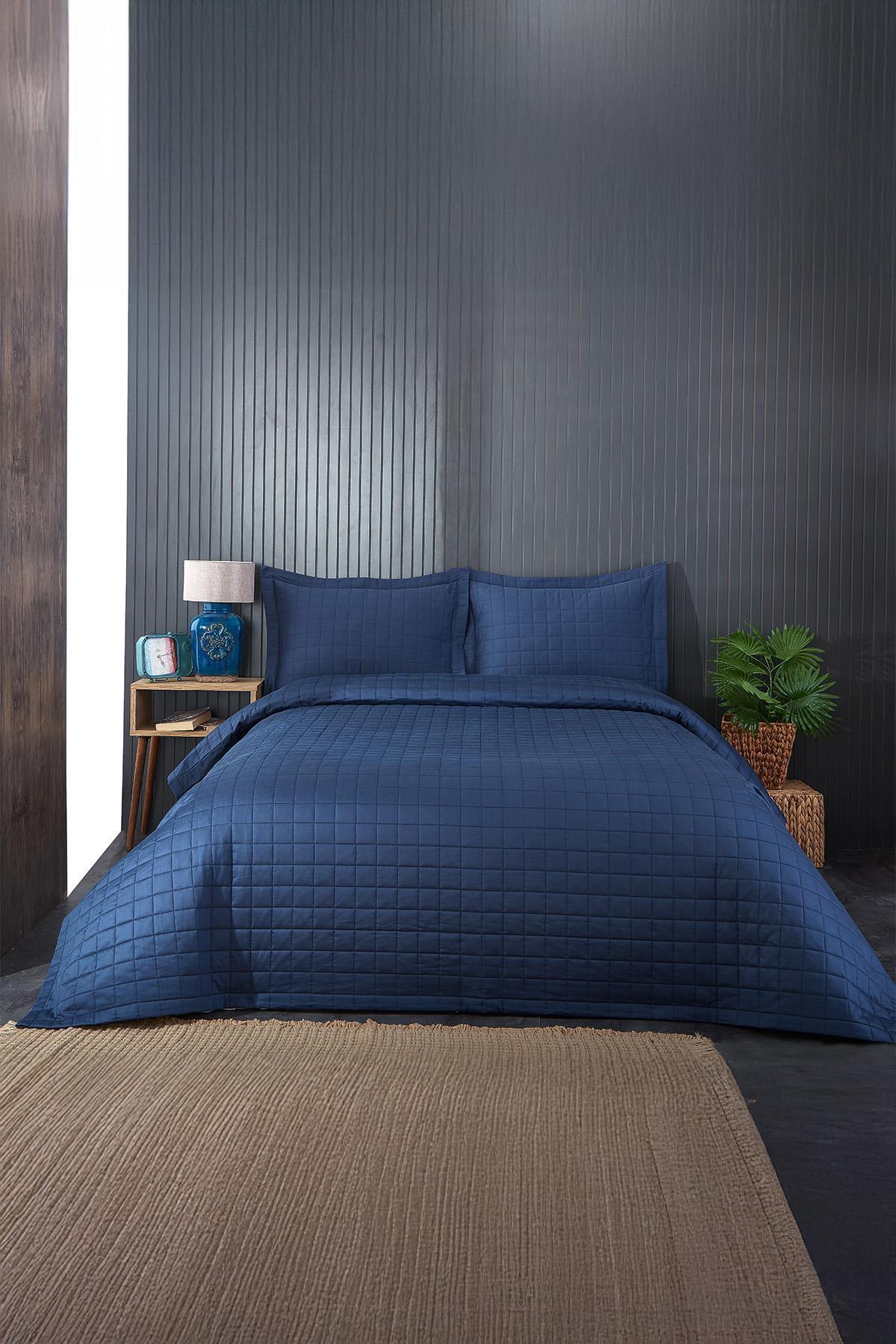 Couvre-lit double capitonné bleu marine et ensemble de taies d'oreiller dans une chambre moderne