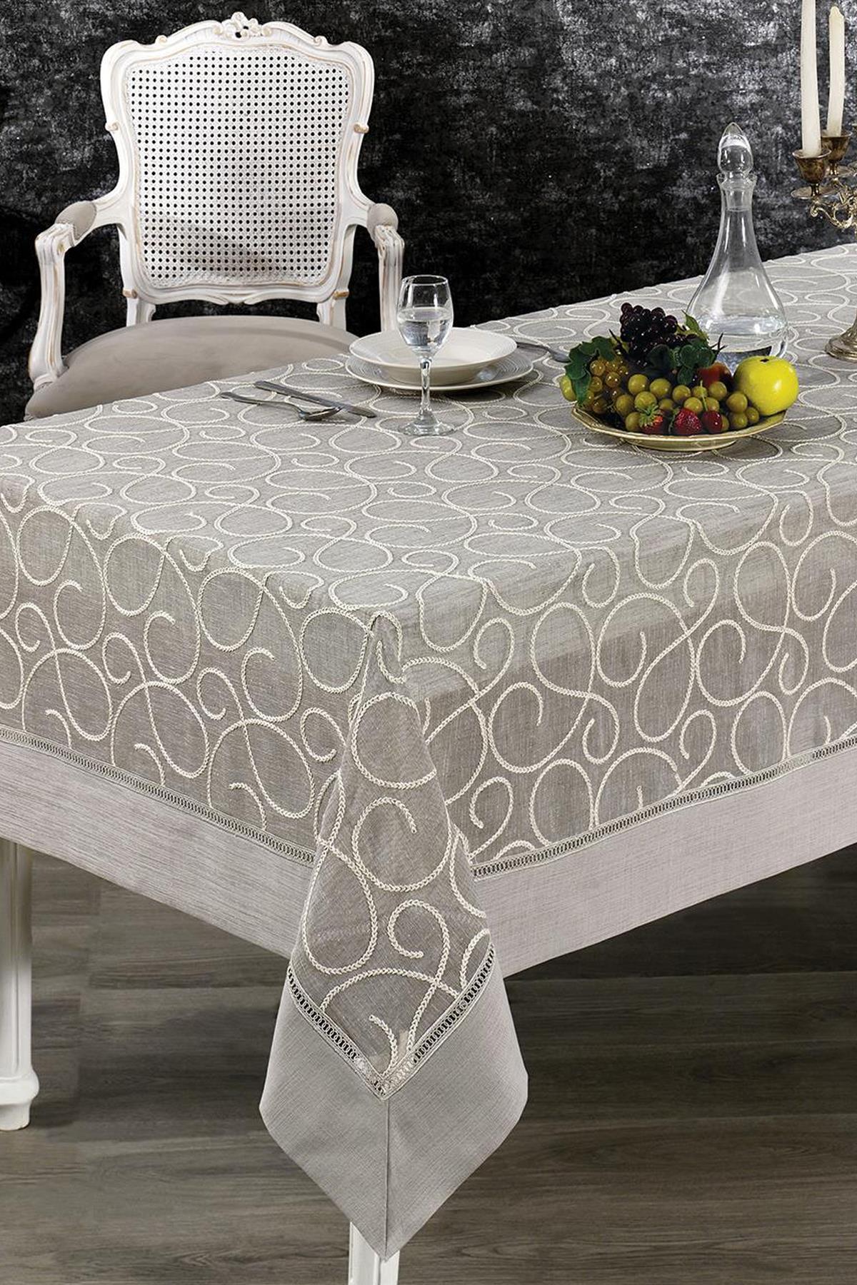Nappe à motifs antitache, dressée sur une table élégante avec une coupe de fruits et une carafe en verre