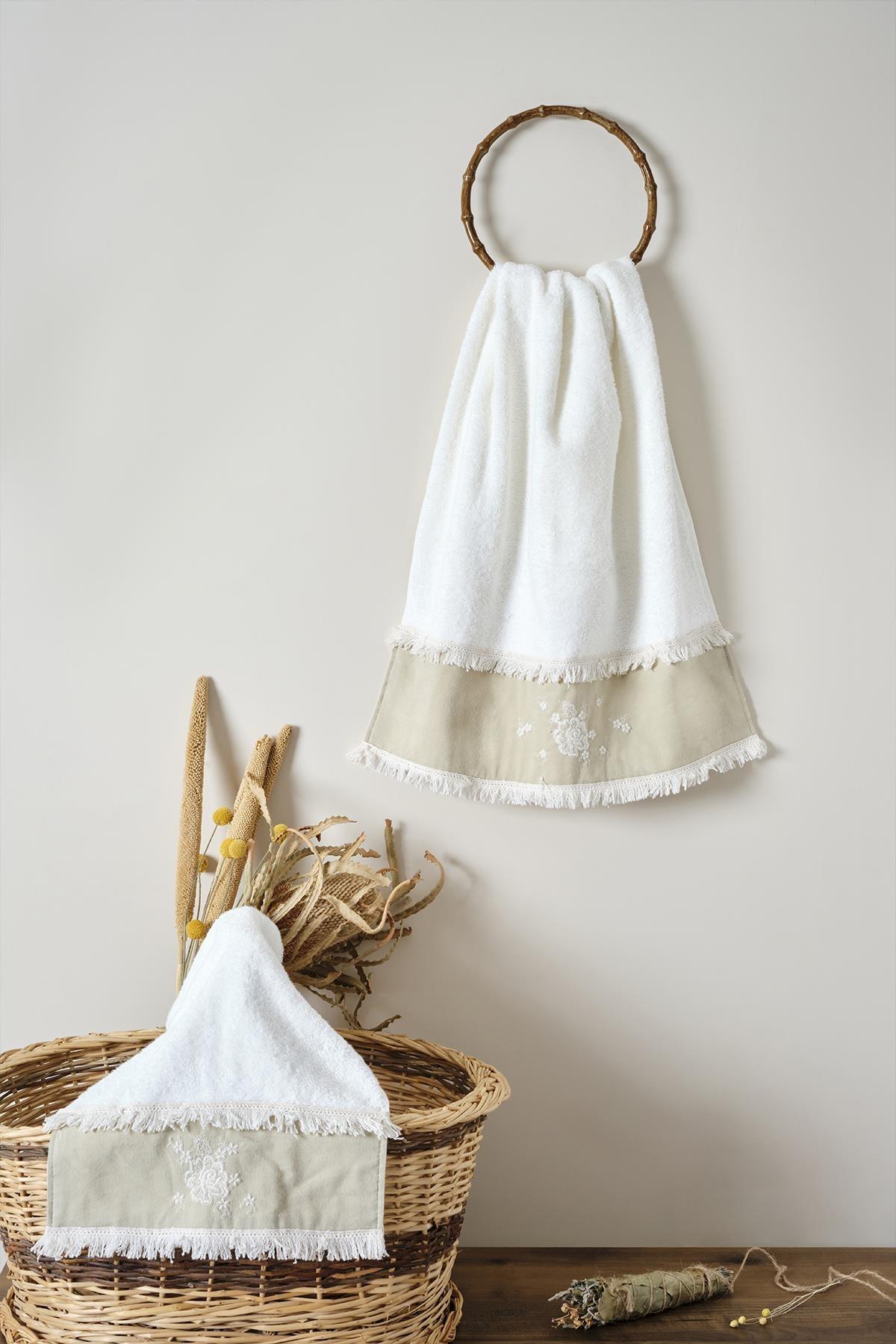 Serviette blanche à détails en dentelle beige avec pompons, présentée avec un panier et des fleurs séchées décoratives
