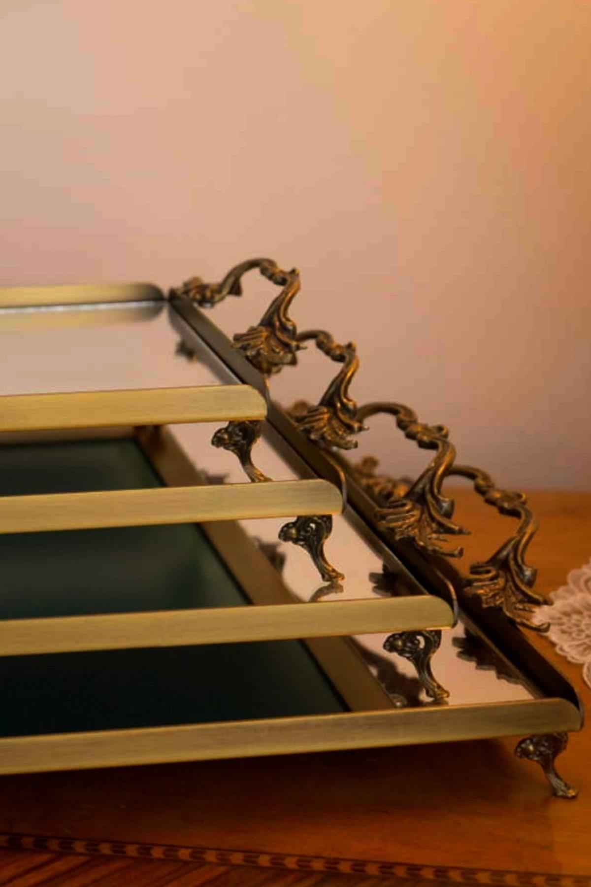 Grand plateau en métal avec poignées élégantes et détails vieillis, surface réfléchissante, pour une présentation décorative sur table.