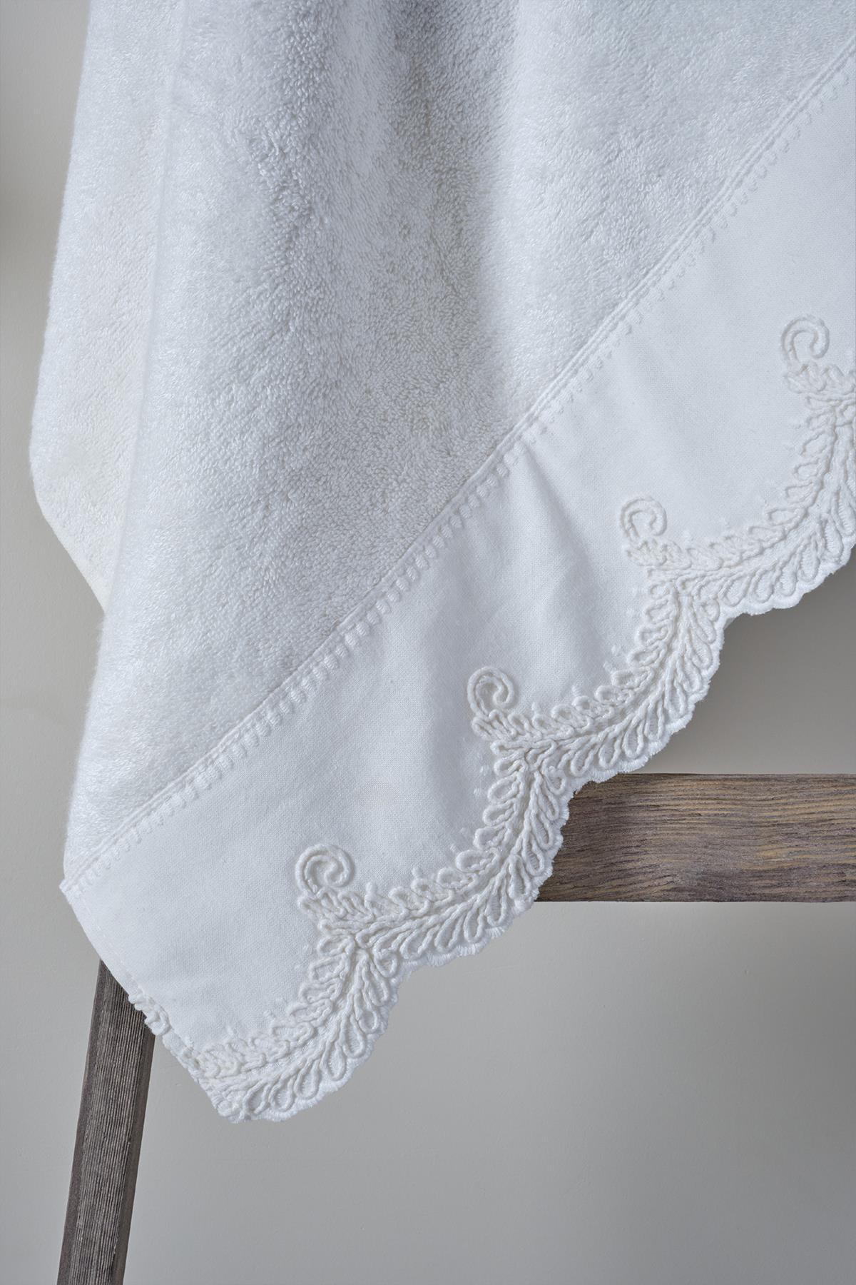 Serviette de visage en coton blanc avec bordure brodée, 50x90 cm, sur cintre en bois